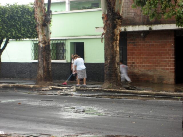 Señoras quitando la arena de sus banquetas