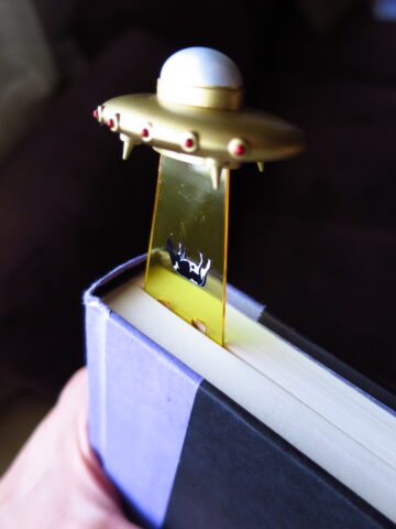 Separador de libros de platillo volador abduciendo una vaca.