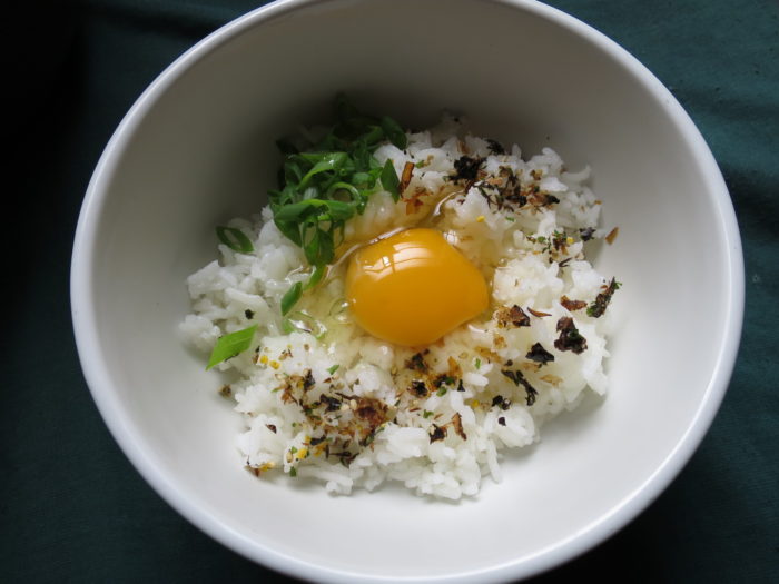 Huevo sobre arroz recien hecho con tallo de cebollin y furikake
