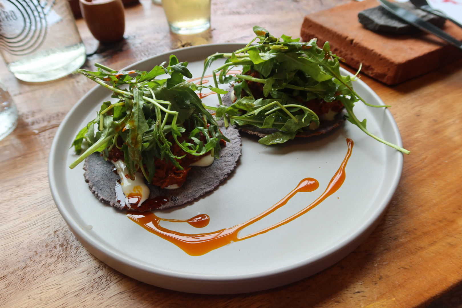 Pato con dos tacos de pato ahumado con oregano y arúgula